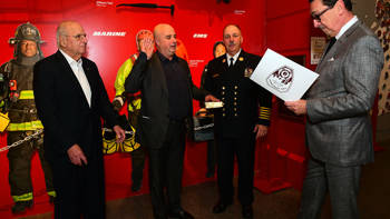 Andreas Dracopoulos, President of the Stavros Niarchos Foundation, joined by members of the New York Fire Department, is proclaimed Honorary Chief of the New York Fire Department Battalion